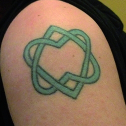 Tatuaje del Unified Heart sobre el hombro de una fan de Cohen